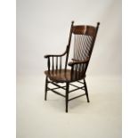 A 19th century American style oak elbow chair, with a concave top rail above a stick back and shaped