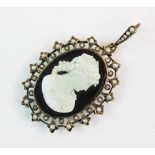 A Victorian pendant set with a hard stone carved cameo, the central black and white oval cameo
