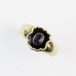 A Victorian mourning ring, comprising a central mixed cut oval amethyst set to a black enamelled