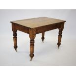 A Victorian pine kitchen table, the rectangular plank top with rounded corners, raised upon turned