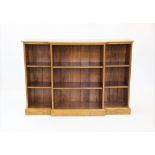 A Victorian style golden oak breakfront open bookcase, late 20th century, the moulded top above an