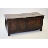 An early 18th century oak coffer, the hinged and moulded two plank top enclosing a fitted candle