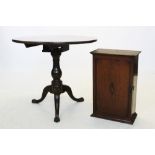 A George III oak tripod table, the circular top raised upon a ring turned baluster pedestal, three