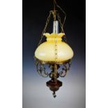 A 20th century hanging light designed as an oil lamp, of typical form, with curled floral details,
