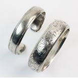 A vintage silver hinged bangle, the front section with engraved scrolling foliate decoration, with