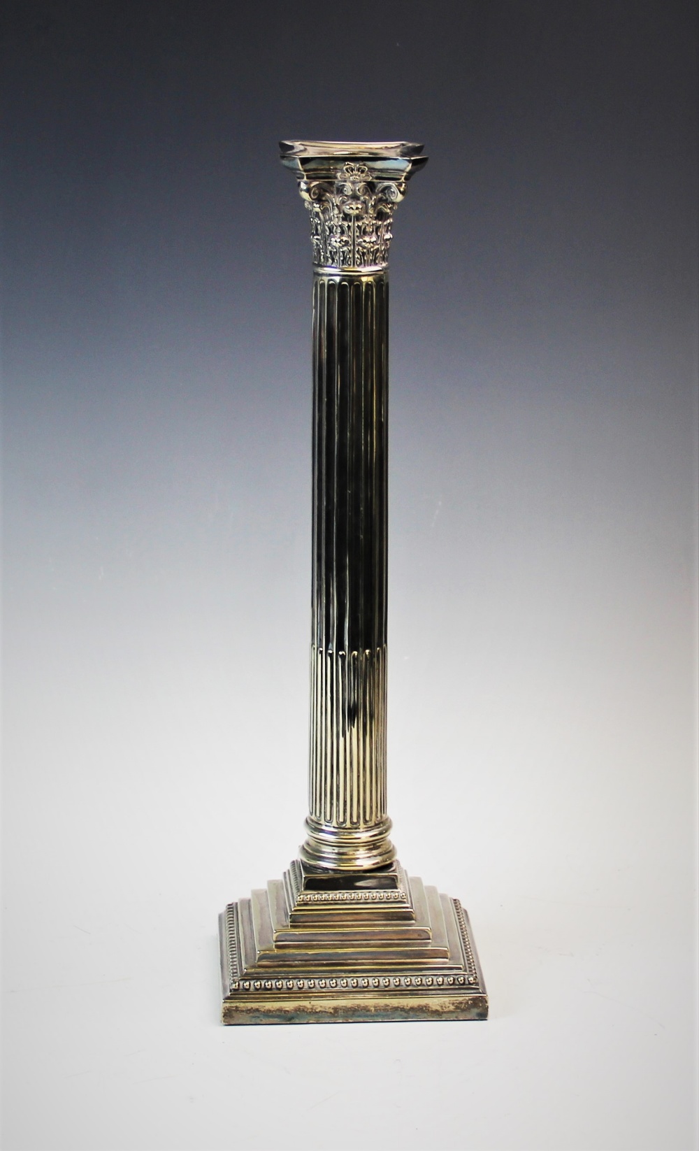 An early 20th century silver plated candlestick, designed as a Corinthian capital, atop a stop-