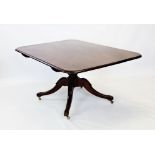 An early 19th century mahogany breakfast table, the rectangular cross banded tilt top with rounded