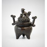 A Chinese bronze censer and cover, early 19th century, of ovoid form on tripod feet with engraved