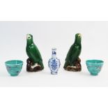 A pair Chinese porcelain parrots, decorated in a green glaze, to naturalistic brown bases, each 15cm