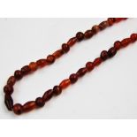 A Roman period carnelian bead necklace, with spherical, ovoid, bi-conical and barrel shaped beads,