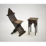 An early 20th century Syrian hardwood folding chair, of articulated form with carved scroll detail