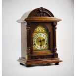 A late 19th century oak cased German bracket clock, domed architectural cased supported by fluted