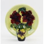 A Moorcroft plate, decorated in the Hibiscus pattern against a yellow ground, painted monogram for