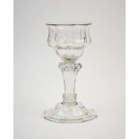 An 18th century champagne glass, the octagonal ogee form bowl on eight sided knopped pedestal stem
