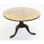 A George III oak tripod table, the circular top raised upon a reduced ring turned pedestal, three