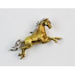 An 18ct gold diamond set stylized horse brooch, the yellow gold body with a white gold mane and tail