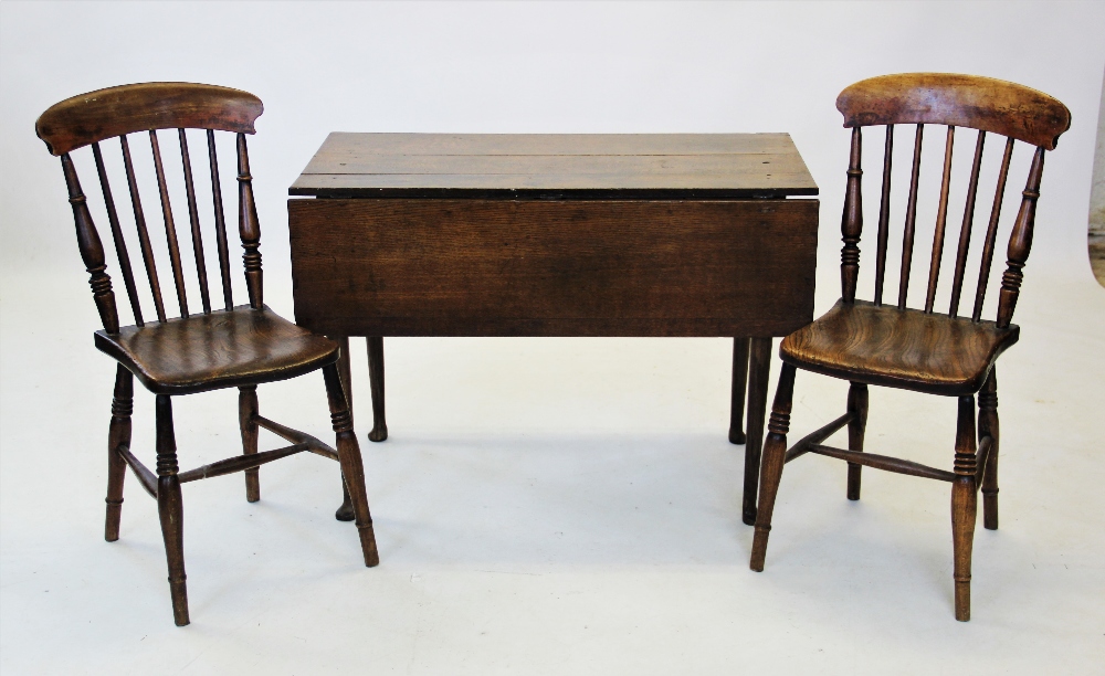 An 18th century oak drop leaf kitchen table, the rectangular plank top raised upon tapering