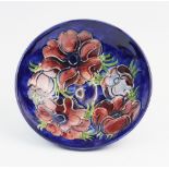 A Moorcroft footed bowl, decorated in the Anemone pattern against a cobalt blue ground, painted