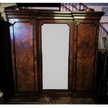 A Victorian burr walnut inverted breakfront triple wardrobe, with a stepped cornice above a