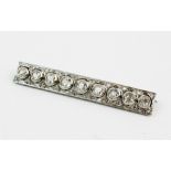 An early 20th century diamond bar brooch, comprising nine round mine cut diamonds, collet set, in