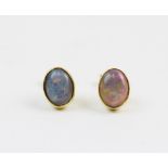 A pair of opal stud earrings, each comprising an oval opal cabochon measuring 8mm x 5mm, collet