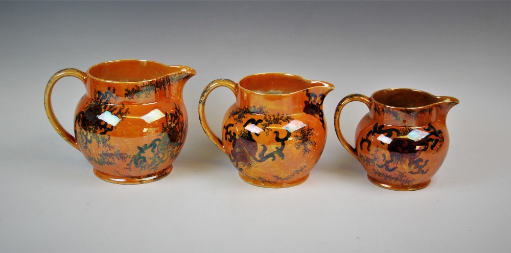 Three graduated Bursley ware Dragon pattern lustre jugs by Frederick Rhead, applied with fiery - Image 2 of 4