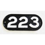 A vintage cast iron railway locomotive number plate, of oval form, the cast numbers '223' painted in