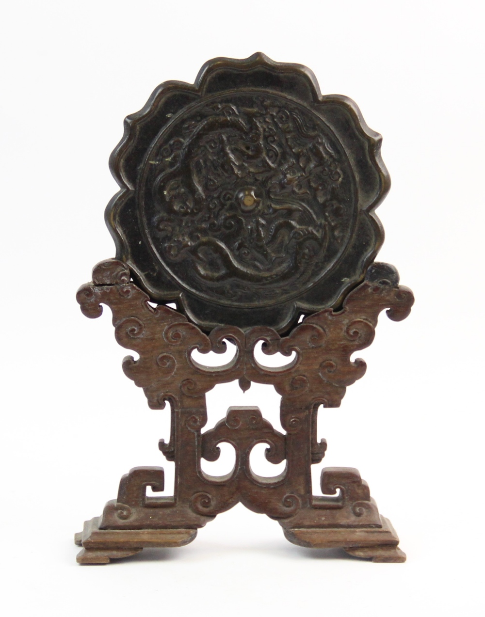 A Chinese bronze hexafoil lotus mirror, Ming dynasty, cast in relief with two confronting dragon