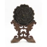 A Chinese bronze hexafoil lotus mirror, Ming dynasty, cast in relief with two confronting dragon