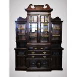 An Edwardian mahogany breakfront display cabinet, with a twin swan neck pediment above a pair of