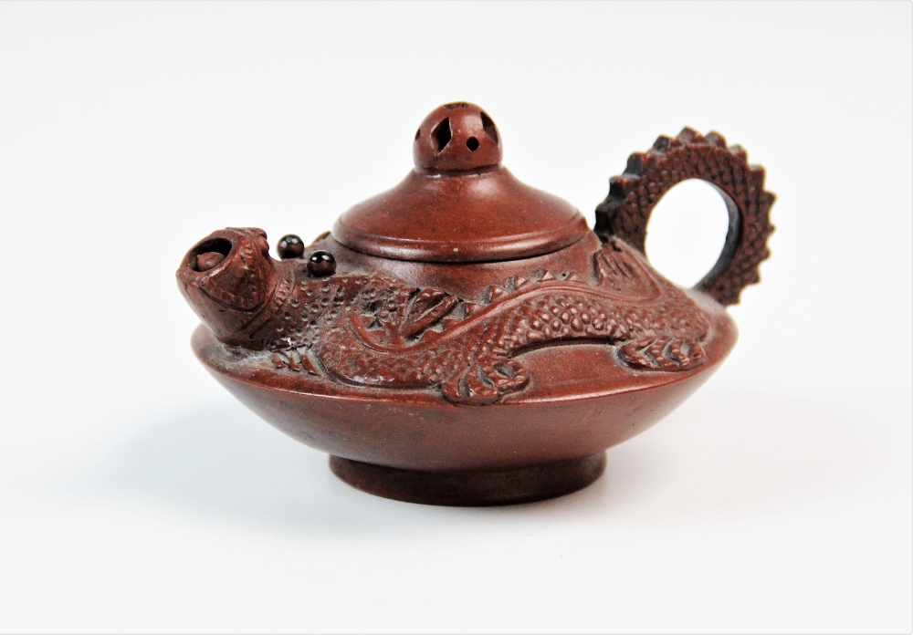 A Chinese Yixing terracotta teapot, decorated with a stylised dragon, removable cover with pierced