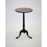 A George III mahogany wine table, the circular tilt top raised upon a ring turned tapering pedestal,