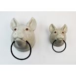 A graduated pair of continental ceramic towel rails, 20th century, modelled as pig masks, the