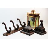 An oak wall mounted coat/hat rack, with three 'S' shaped hooks applied to an oval plinth, 63cm wide,