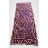 A Kurdish wool runner, the central panel with repeating stylised flower heads on a deep indigo