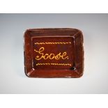 A late 19th century slipware dish, of canted rectangular form, inscribed 'GOOSE' within a stylized