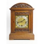 A late 19th/early 20th German oak cased bracket clock, by Mathias Bauerle, the arched case with a