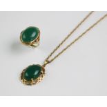 A pendant set with a green cabochon stone, all within a scroll surround stamped '750', with an