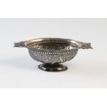 A Dutch white metal brandy bowl, the oval, pedestal bowl with embossed vignettes of rural views,