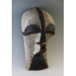 A wooden Songye Kifwebe ritual mask, Democratic Republic of Congo, painted black highlights upon a