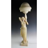 An Art Deco alabaster figural lamp, modelled as an Egyptian revival dancing girl, arms raised, below
