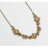 A Victorian style 9ct gold and split seed pearl set necklace, designed as three floral clusters,