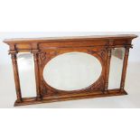 An early 20th century Art Nouveau oak over mantle mirror, the central oval bevelled mirrored plate