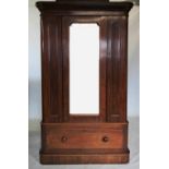 A Victorian mahogany single door wardrobe, with a cavetto cornice above a central mirrored door