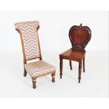 A Victorian mahogany hall chair, the apple shaped back applied with 'C' scroll carving and centred