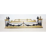 A George III style brass and painted iron fender, with torch flame finials above painted metal leafy