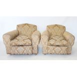 A pair of 1930's deep seated fireside armchairs, covered in foliate pattern fabric, raised upon