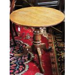 A George III oak tripod table, the circular five plank top raised upon a baluster pedestal, three