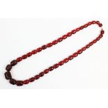 A cherry amber necklace, designed as a single strand of forty three graduated beads, gross weight