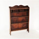 A late 19th/early 20th century oak open bookcase, with a shaped gallery above four pigeon holes